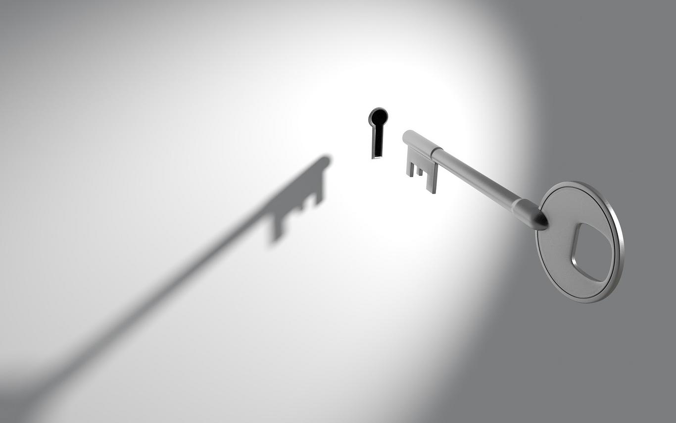 Old fashioned key hovering in front of key hole 