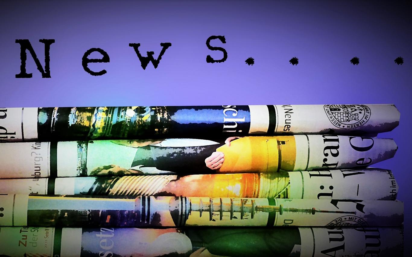 Colourful stack of folded newspapers with the text "News...." above it.